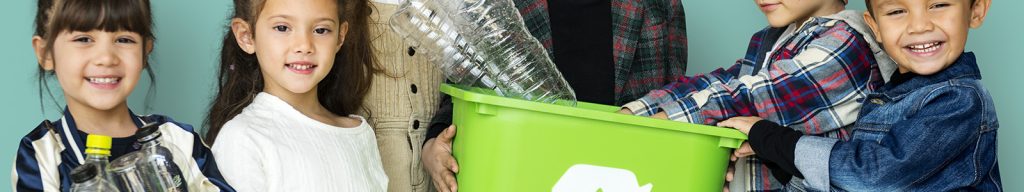 Group of elementary school children surrounding a recycling can