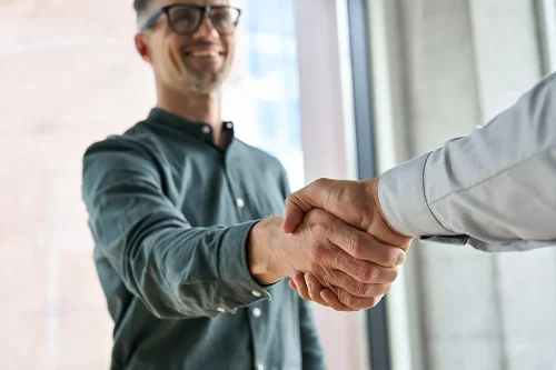 Casual business professional smiles during handshake