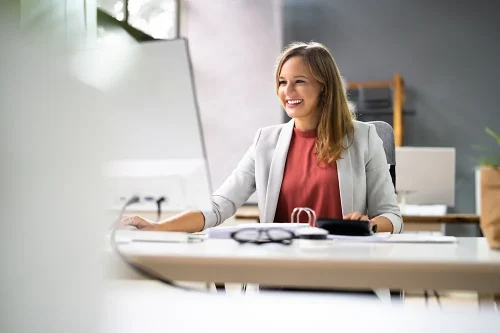 Smiling procurement professional using computer to shop online